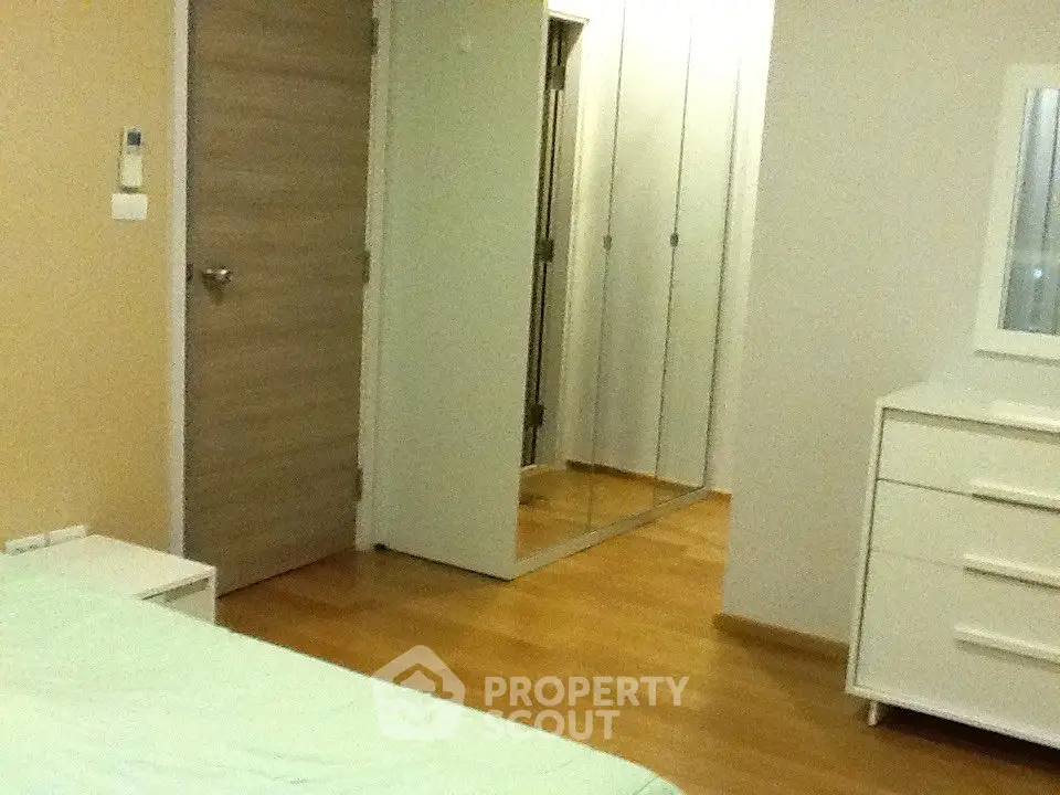 Spacious bedroom with wooden flooring and mirrored closet doors