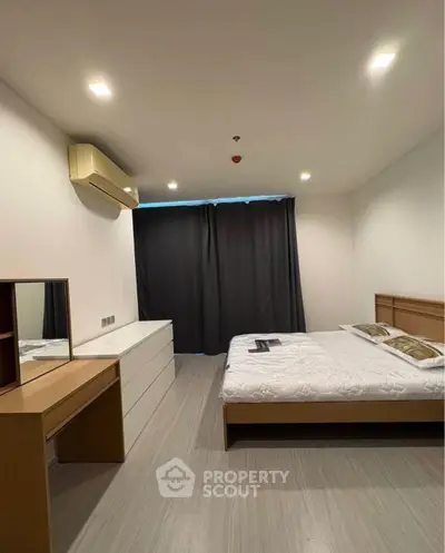 Spacious bedroom with modern furnishings and ample natural light