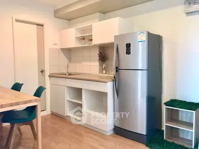 Modern kitchen with sleek fridge and dining area in stylish apartment