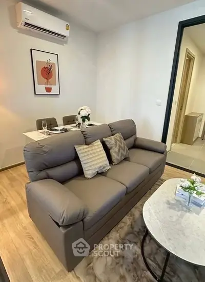 Modern living room with cozy sofa and elegant dining area in stylish apartment.