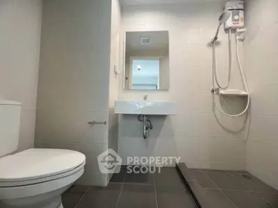 Modern bathroom with sleek fixtures and walk-in shower in a contemporary apartment.