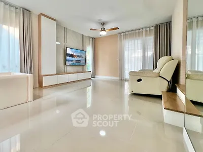 Spacious modern living room with sleek flooring and cozy seating area.