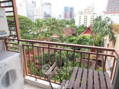 Charming balcony with city view and lush greenery, perfect for relaxation.