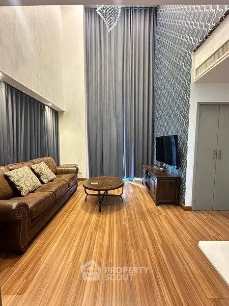 Luxurious living room with high ceilings, elegant decor, and modern furnishings.