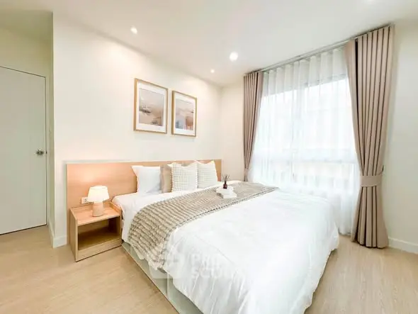 Bright and cozy bedroom with modern decor and large window for natural light.