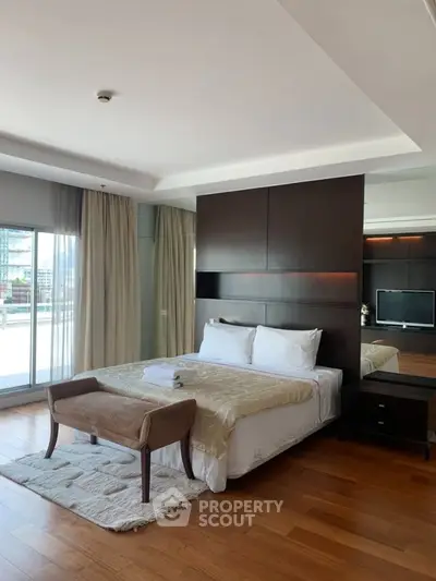 Luxurious bedroom with elegant decor and spacious layout, featuring hardwood floors and large windows for natural light.