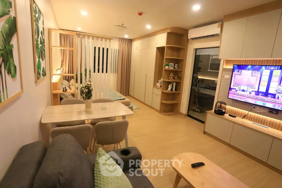 Modern living room with stylish decor and open layout, featuring a cozy dining area and entertainment setup.