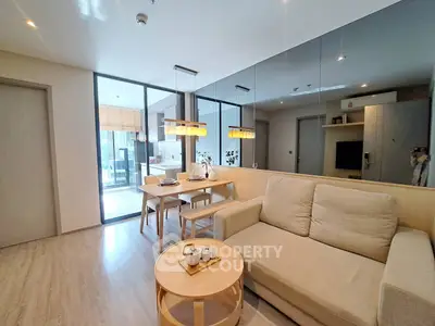 Modern living room with cozy beige sofa, wooden coffee table, and dining area in open layout apartment.