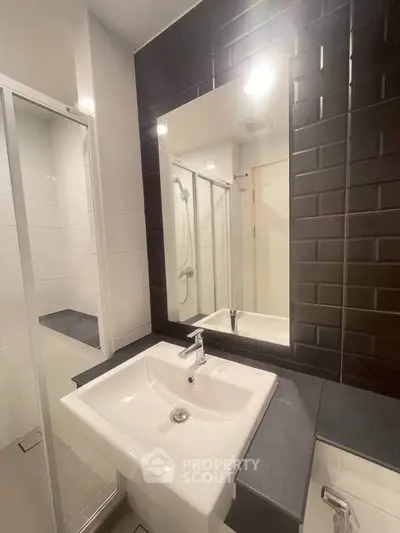 Modern bathroom with sleek black tiles and white fixtures