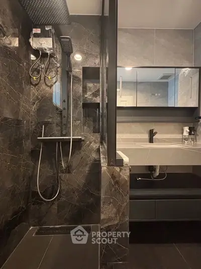 Luxurious modern bathroom with sleek black marble tiles and high-end fixtures.