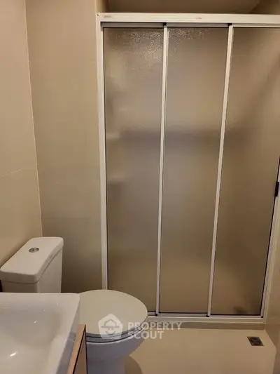 Modern bathroom with sliding shower door and sleek fixtures.