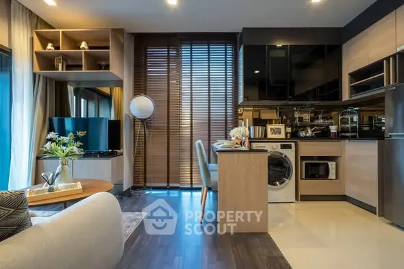 Modern open-layout living room and kitchen with stylish decor and natural light.