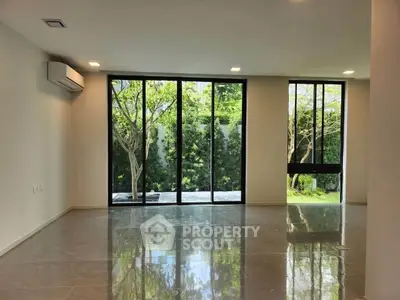 Spacious modern living room with large windows and garden view, perfect for natural light lovers.