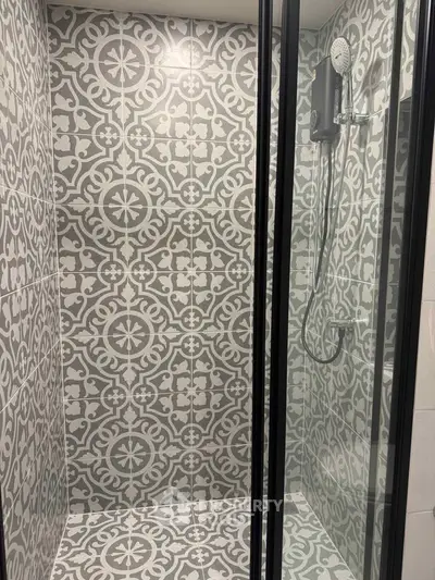 Stylish bathroom shower with intricate tile design and modern fixtures