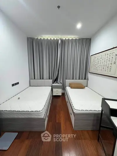 Modern twin bedroom with sleek wooden flooring and elegant decor