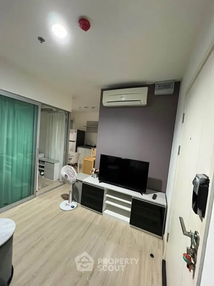 Modern living room with sleek TV setup and air conditioning in a cozy apartment
