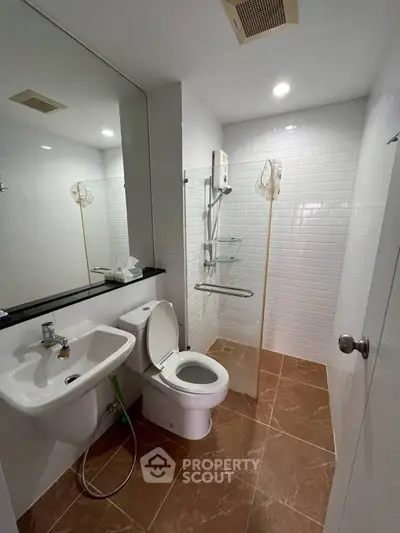Modern bathroom with sleek fixtures and tiled walls in a contemporary real estate property.