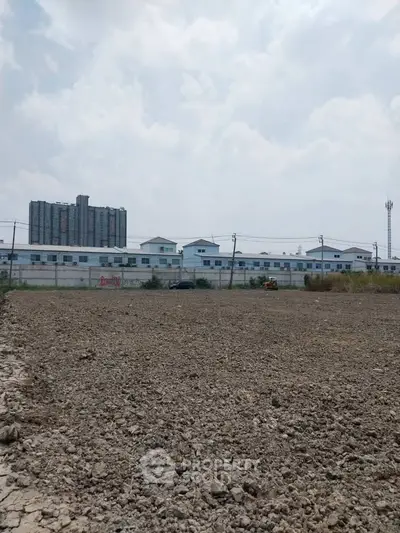 Expansive land plot with urban backdrop, ideal for development opportunities.