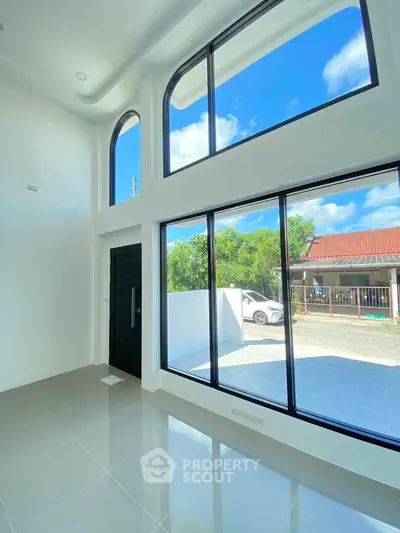 Bright modern living room with high ceilings and large windows offering stunning natural light.