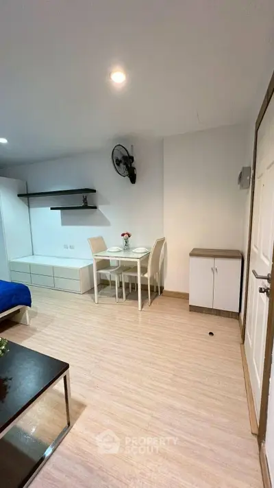 Modern living room with minimalist furniture and dining area in a cozy apartment.