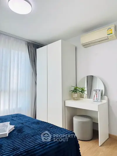 Modern bedroom with stylish decor, featuring a cozy bed, sleek wardrobe, and elegant vanity area.