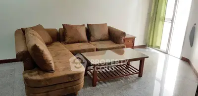 Spacious living room with cozy brown sectional sofa and glass coffee table, perfect for relaxation.