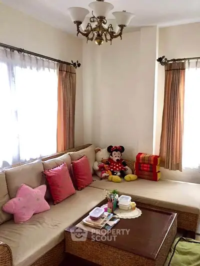 Cozy living room with plush seating and natural light, perfect for relaxation and family gatherings.