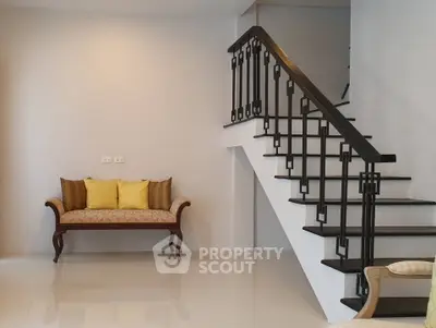 Elegant interior with stylish staircase and cozy seating area, perfect for modern living.