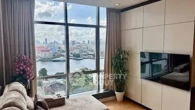 Luxurious living room with stunning city and river view, featuring modern decor and large windows.