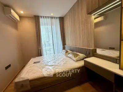 Modern bedroom with large window and stylish wooden accents in a high-rise apartment.