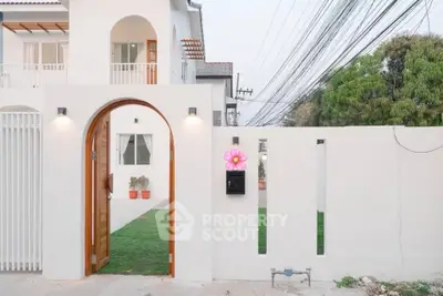 Charming modern house entrance with arched wooden door and white walls