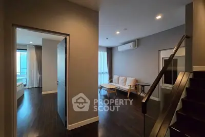 Modern apartment interior with sleek dark wood flooring and cozy living area