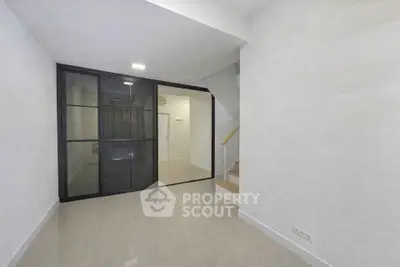 Modern minimalist interior with glass partition and staircase