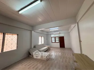 Spacious living room with modern sofa and natural light, perfect for relaxation and entertaining.