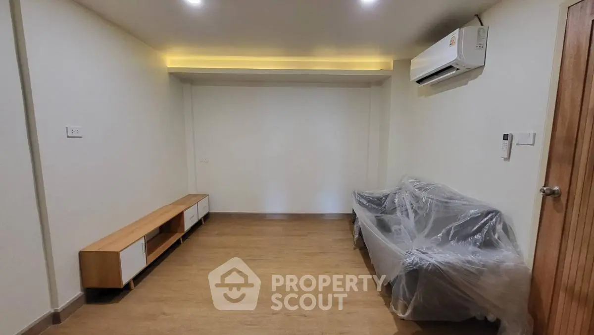 Spacious living room with modern air conditioning and sleek wooden flooring