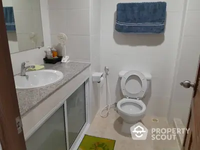 Modern bathroom with sleek fixtures and granite countertop in a cozy home setting.