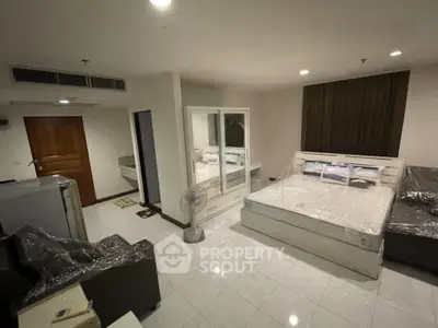 Spacious modern bedroom with sleek furniture and ample lighting, perfect for comfortable living.