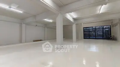 Spacious industrial-style open space with polished floors and high ceilings, ideal for versatile use.