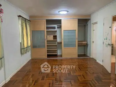 Spacious bedroom with parquet flooring and built-in wardrobe
