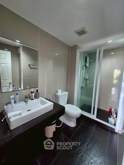 Modern bathroom with sleek design, featuring a glass shower enclosure and stylish vanity.