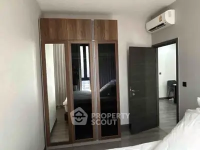 Modern bedroom with sleek wardrobe and air conditioning unit, offering comfort and style.