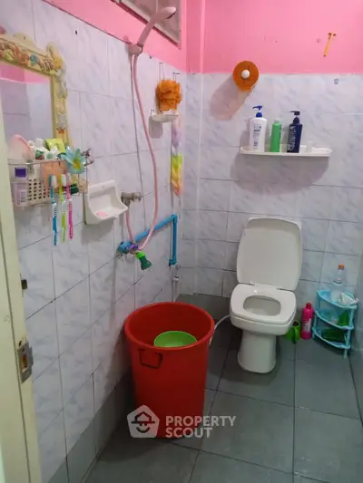 Cozy bathroom with essential amenities and colorful decor accents.