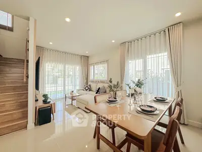 Elegant open-plan living and dining area with natural light and modern decor.