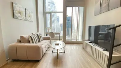 Modern living room with city view, stylish furniture, and large windows.