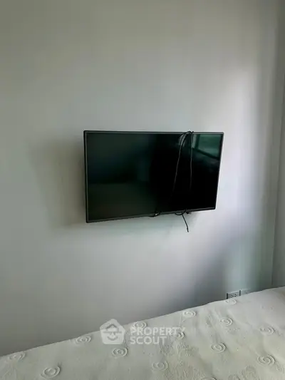 Modern bedroom with wall-mounted TV and minimalist decor