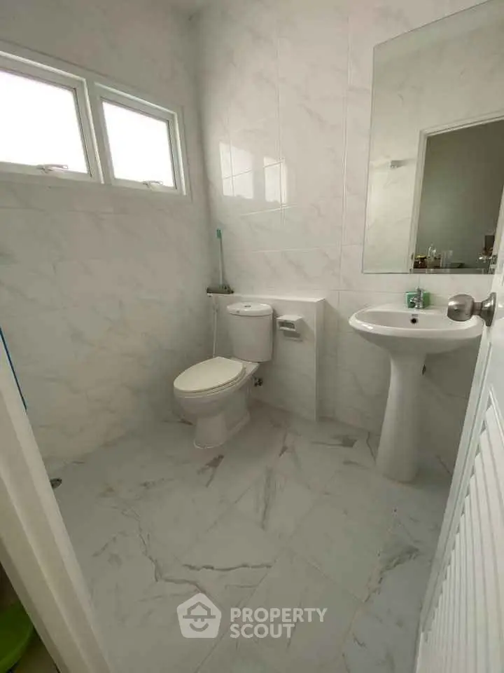 Modern bathroom with white marble tiles and pedestal sink