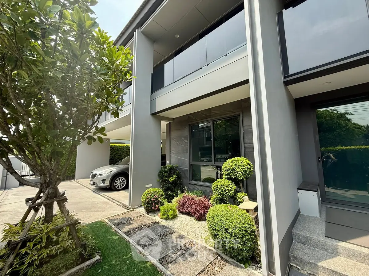 Modern house exterior with landscaped garden and carport