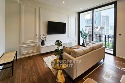 Elegant living room with herringbone wood flooring, white panel walls, and a large window leading to a balcony with city views.