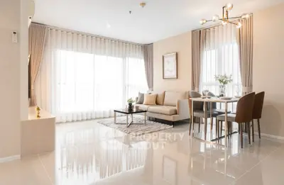 Modern living room with elegant decor, large windows, and stylish furniture in a bright, open space.