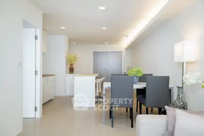 Modern dining area with elegant decor and open kitchen layout in a bright apartment.